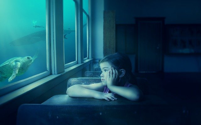 Little girl in a classroom stares out the window into an undersea scene featuring a turtle, whale, shark, and scuba diver