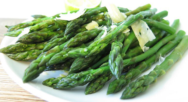 Asparagus on a plate with shaved Parmesan cheese