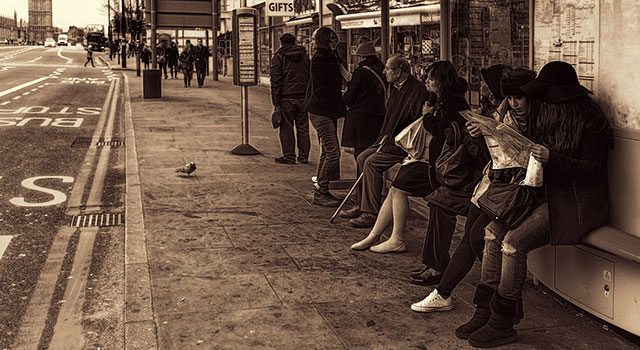 Several people waiting at a bus stop