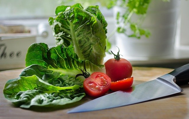 Lettuce leaves and sliced tomato on a kitchen counter