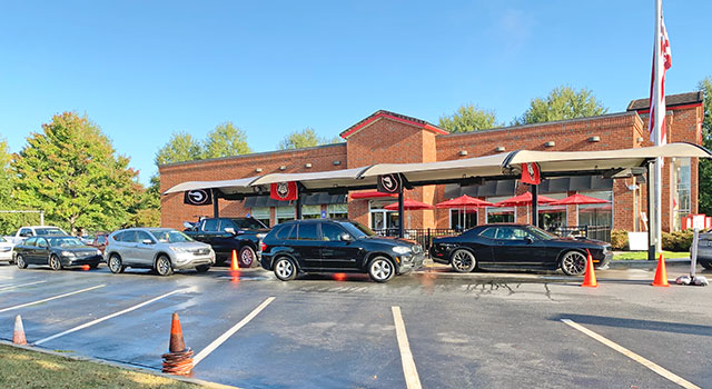 Cars in a double row snaking around a brick Chick-fil-A building
